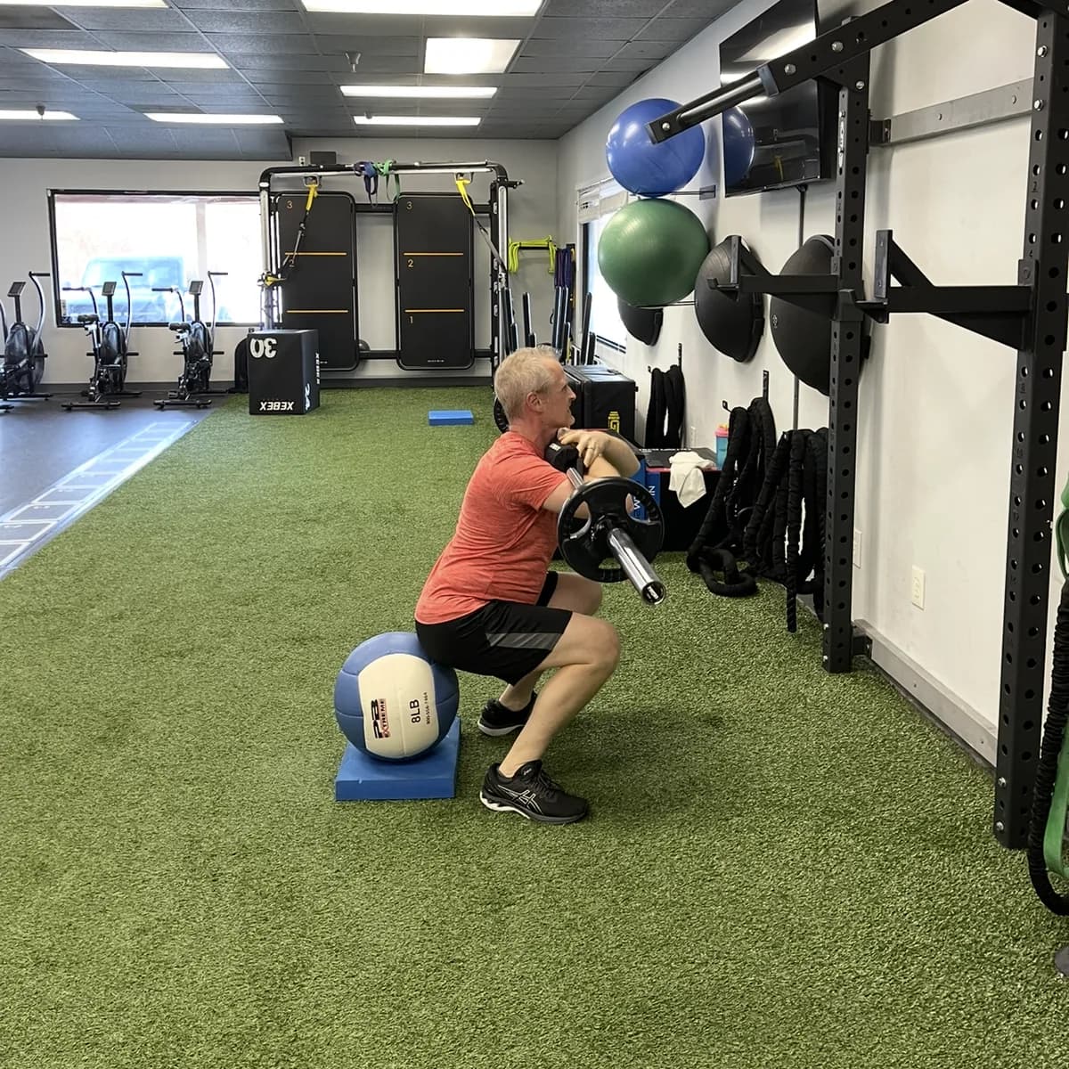 A member doing a front squat to a medicine ball during a private session at 838 Strength and Fitness