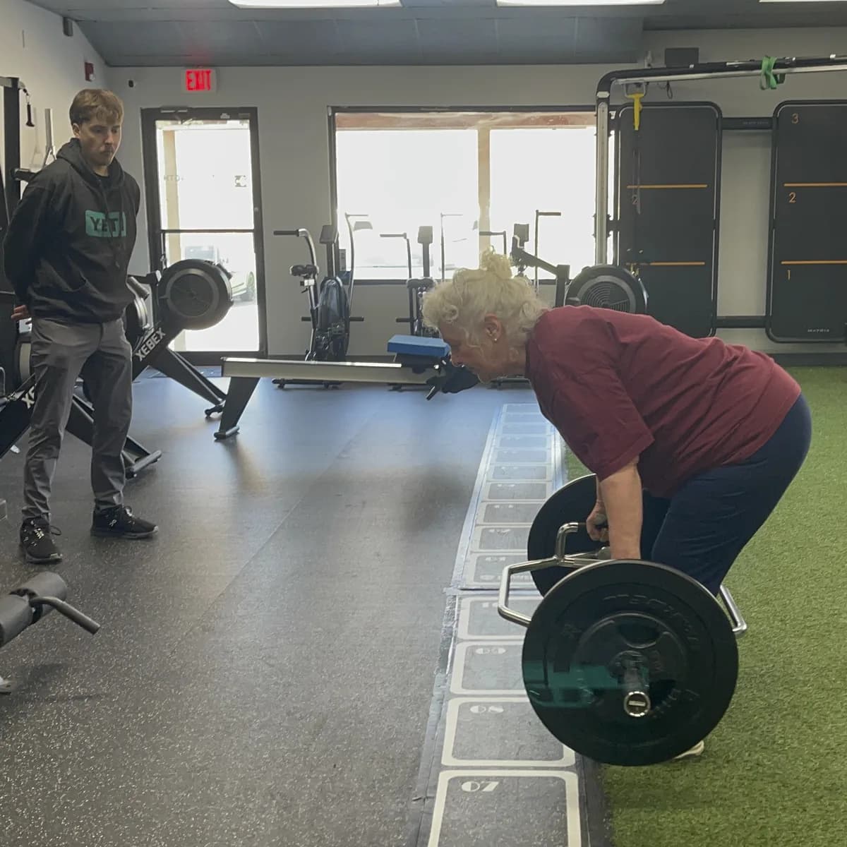 A coach watching a member's trap bar deadlift during a private session at 838 Strength and Fitness