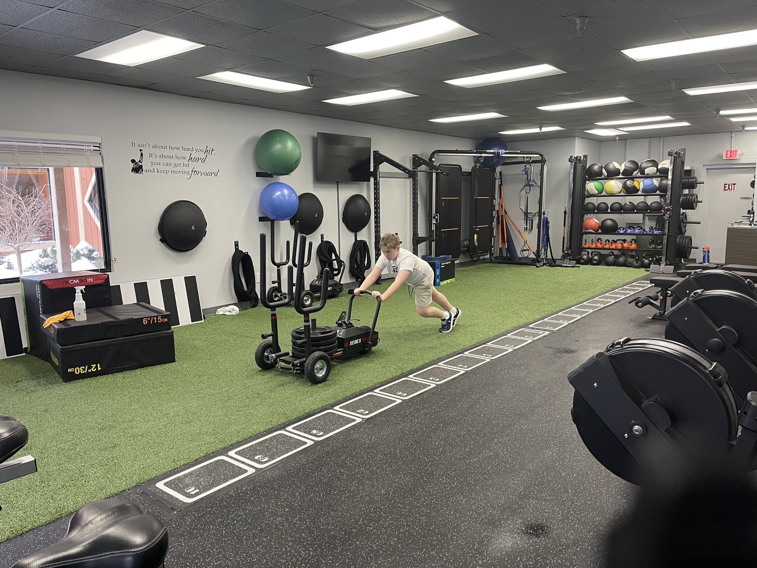 A young athlete pushing a weighted sled at 838 Strength and Fitness in Monroe, CT