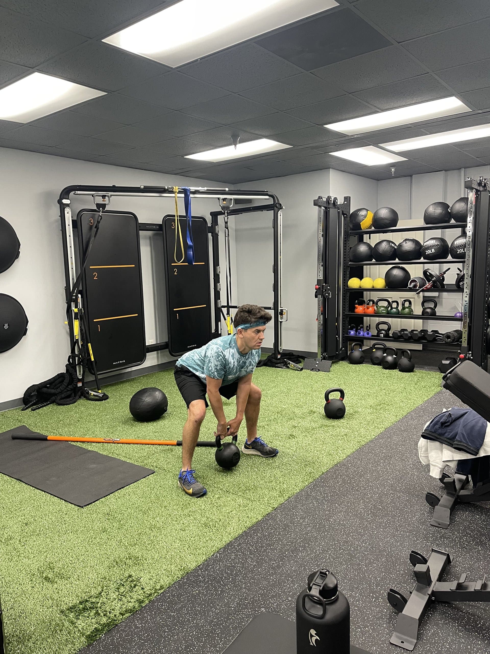 A member mid kettlebell swing at 838 Strength and Fitness in Monroe, CT