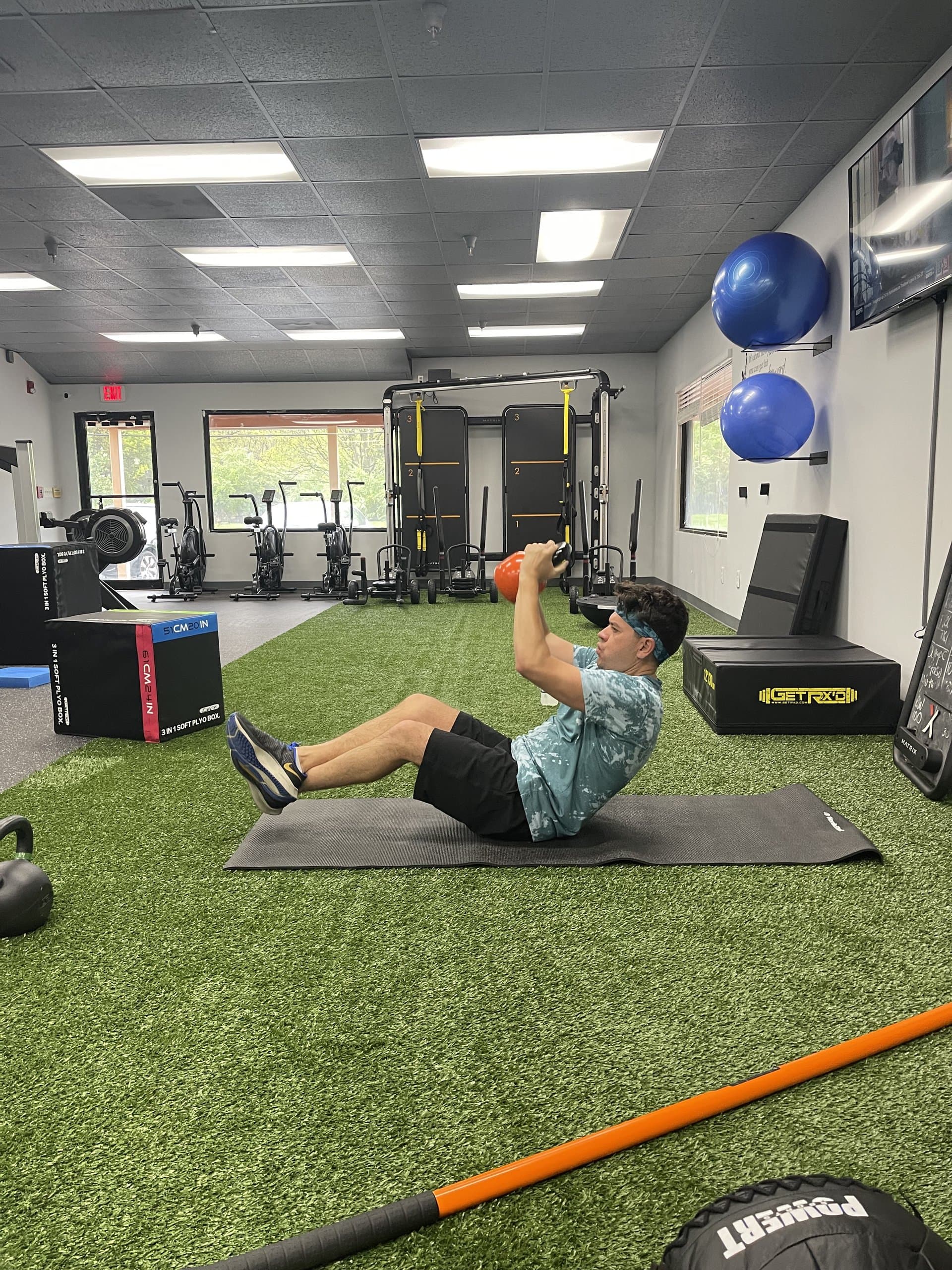 A member pressing a kettlebell overhead at 838 Strength and Fitness in Monroe, CT