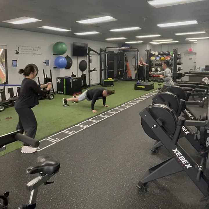Members training at different stations during a semi-private session at 838 Strength and Fitness in Monroe, CT